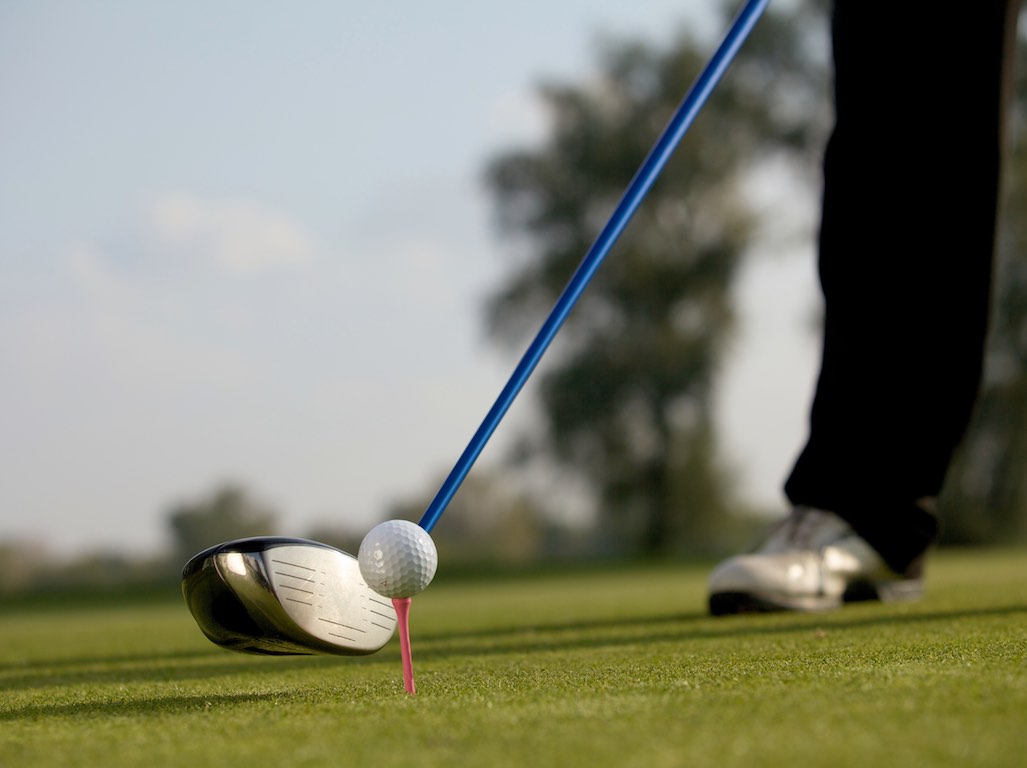 Person playing golf in the tee box